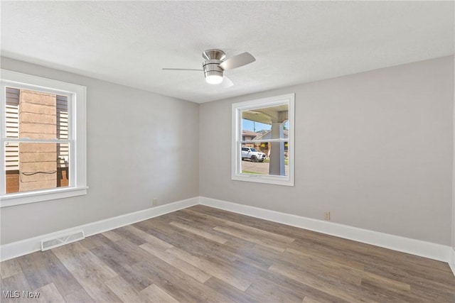 empty room featuring hardwood / wood-style floors, a textured ceiling, and ceiling fan