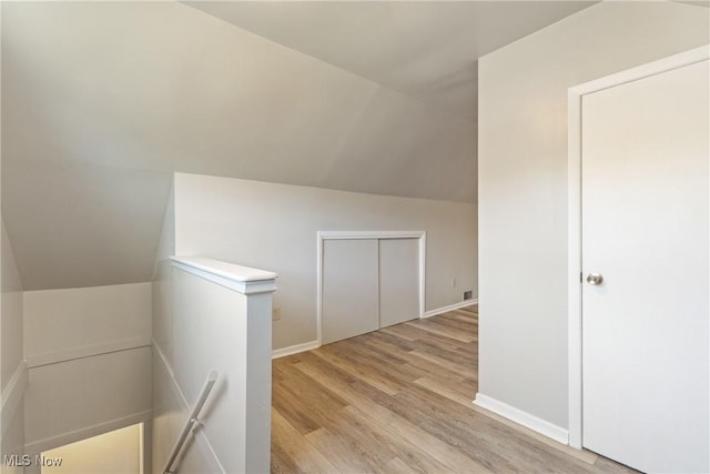 bonus room featuring lofted ceiling and light wood-type flooring