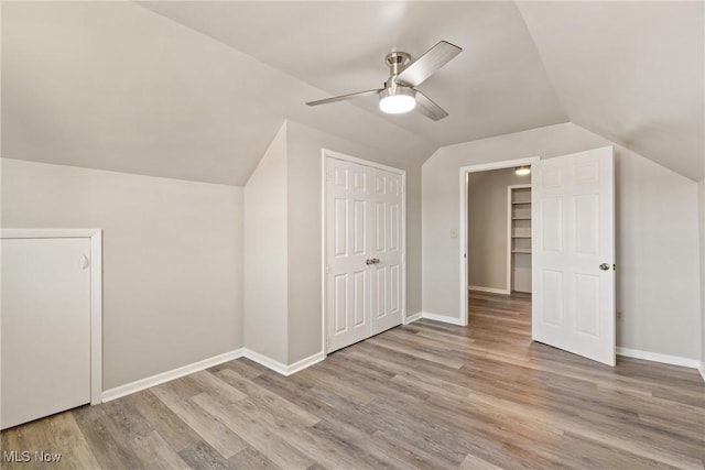 additional living space featuring ceiling fan, light wood-type flooring, and vaulted ceiling