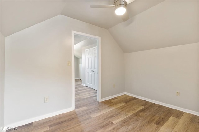 additional living space featuring light hardwood / wood-style floors, vaulted ceiling, and ceiling fan