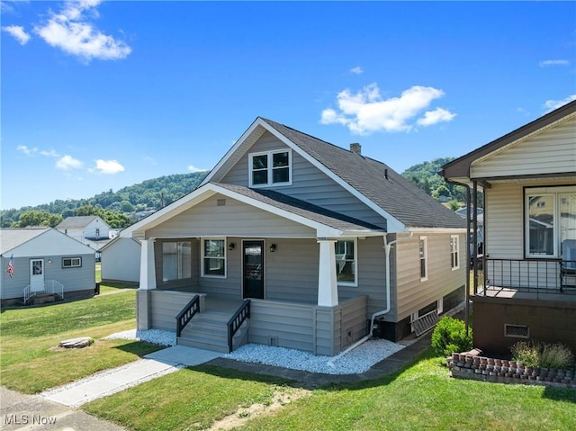 bungalow with covered porch and a front yard