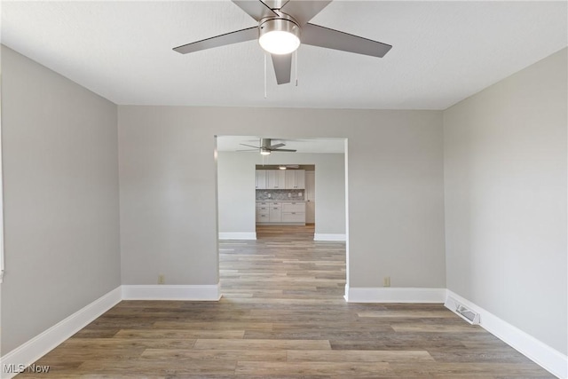 empty room featuring light wood-type flooring and ceiling fan