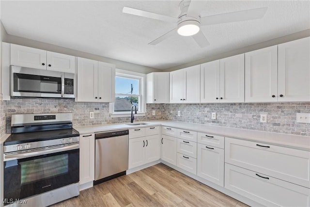 kitchen with backsplash, white cabinetry, sink, and appliances with stainless steel finishes