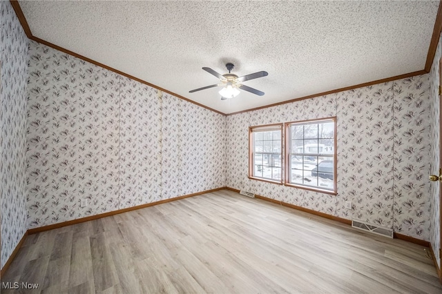 spare room with crown molding, ceiling fan, a textured ceiling, and light hardwood / wood-style floors