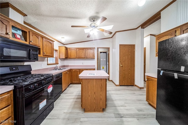 kitchen with a kitchen island, lofted ceiling, light hardwood / wood-style floors, black appliances, and crown molding