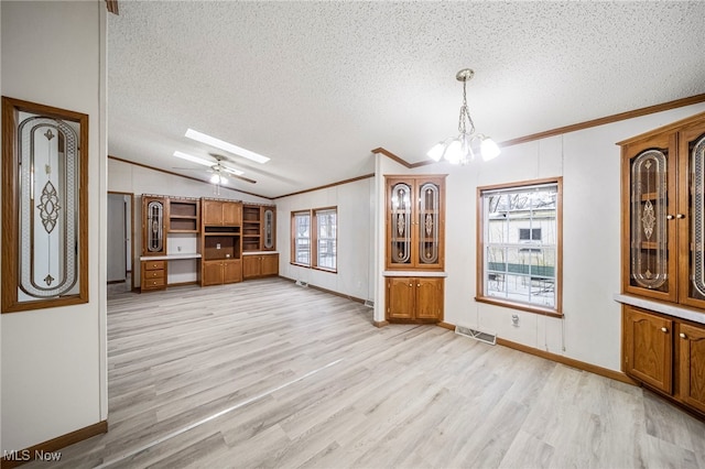 unfurnished living room with crown molding, vaulted ceiling with skylight, a textured ceiling, and light hardwood / wood-style flooring