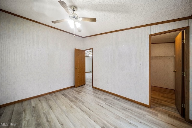 unfurnished bedroom with crown molding, ceiling fan, light hardwood / wood-style flooring, and a textured ceiling