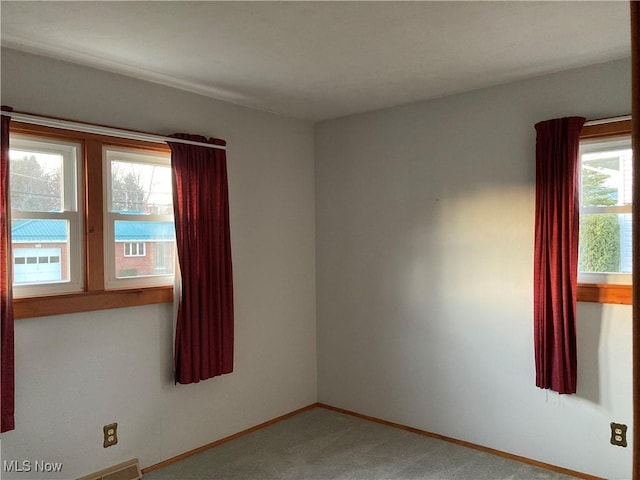 unfurnished room featuring carpet flooring and a healthy amount of sunlight