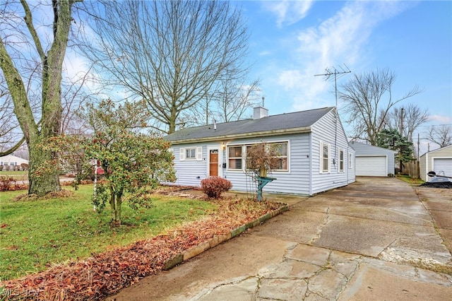 view of front facade featuring a garage, an outbuilding, and a front yard