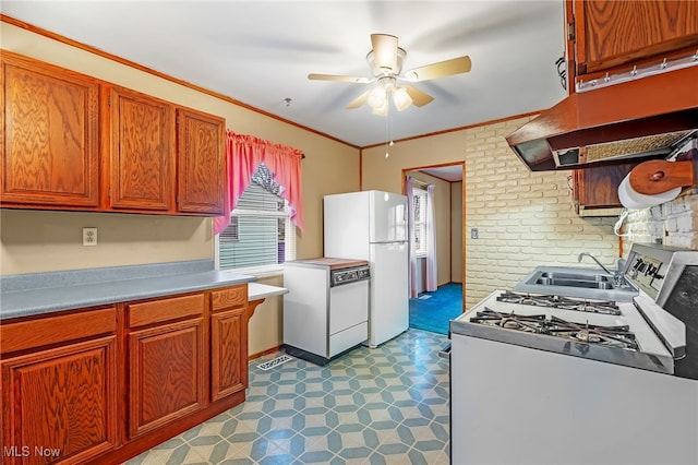 kitchen with white appliances, sink, ceiling fan, ornamental molding, and brick wall