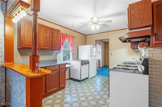 kitchen with white appliances, crown molding, ceiling fan, ornate columns, and washer / clothes dryer