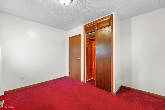 unfurnished bedroom with carpet flooring, a textured ceiling, and a closet