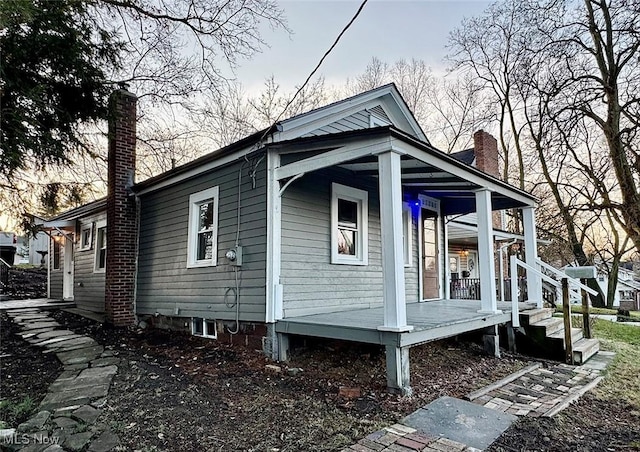 view of side of home featuring covered porch