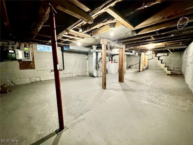 basement featuring electric panel and heating unit