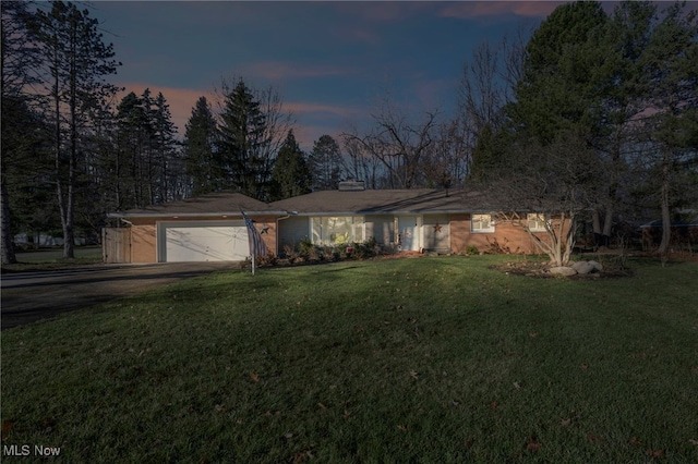 single story home featuring a yard and a garage