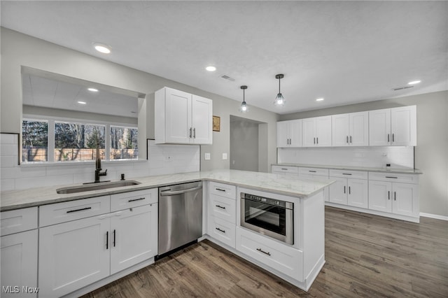 kitchen featuring kitchen peninsula, sink, white cabinets, and appliances with stainless steel finishes