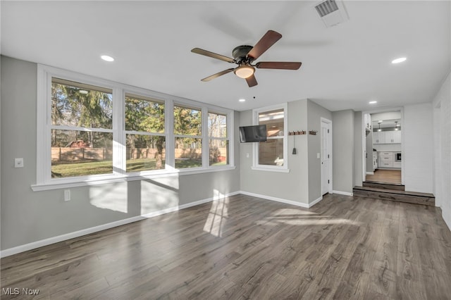 spare room with ceiling fan, a healthy amount of sunlight, and hardwood / wood-style flooring