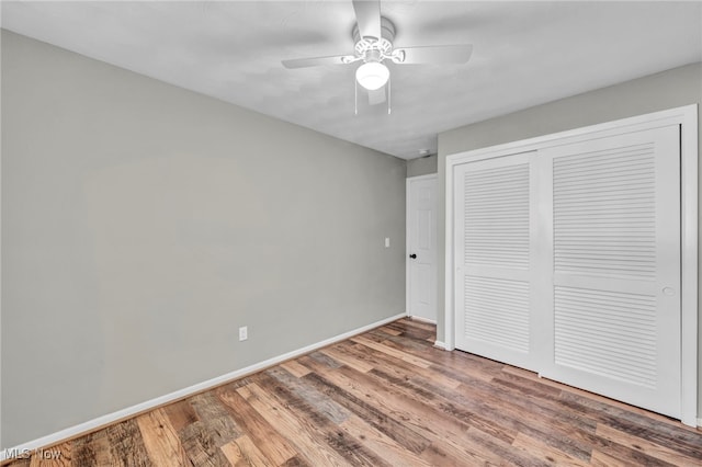 unfurnished bedroom with hardwood / wood-style flooring, ceiling fan, and a closet