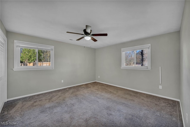 carpeted empty room featuring a wealth of natural light and ceiling fan