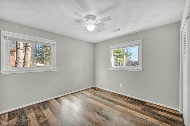 unfurnished room with ceiling fan and dark hardwood / wood-style flooring