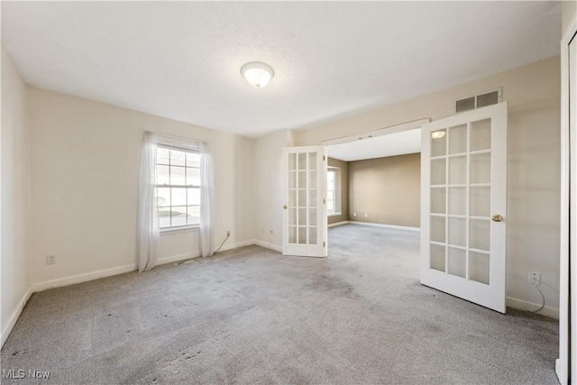 empty room with carpet flooring and french doors