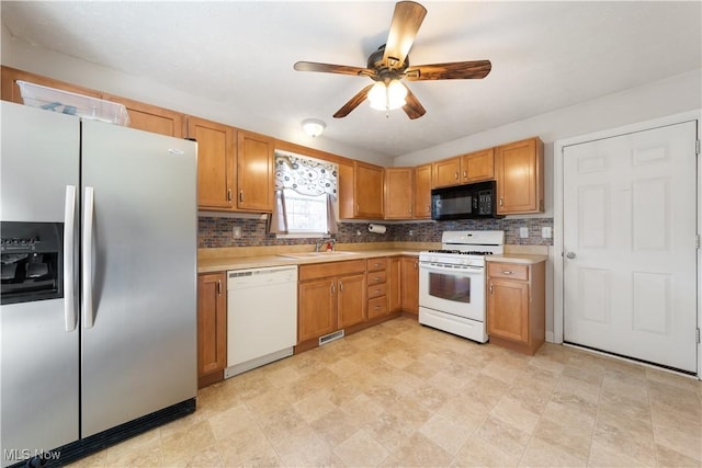 kitchen featuring tasteful backsplash, ceiling fan, sink, and white appliances