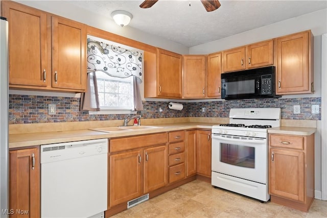 kitchen featuring ceiling fan, sink, backsplash, a textured ceiling, and white appliances