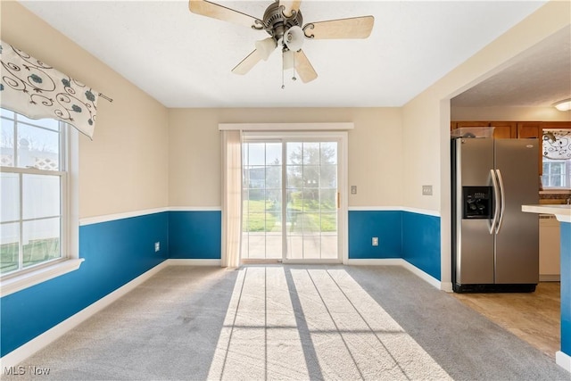 carpeted spare room featuring ceiling fan