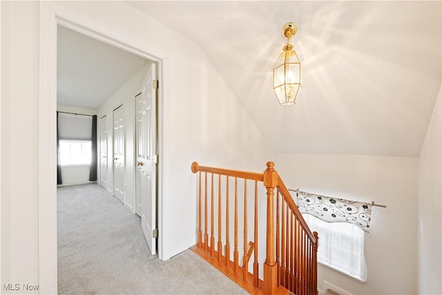 hallway with light carpet and lofted ceiling