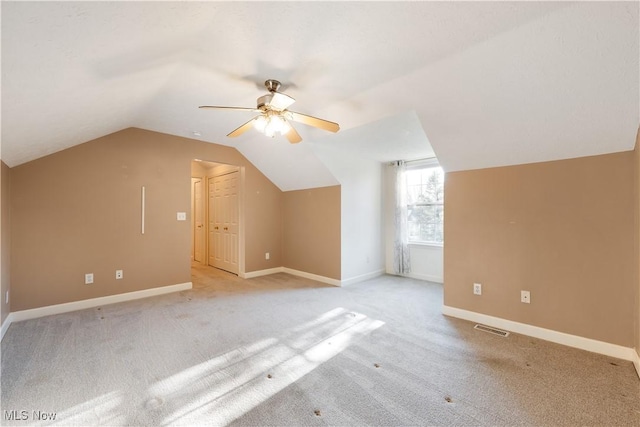 bonus room with ceiling fan, light colored carpet, and vaulted ceiling