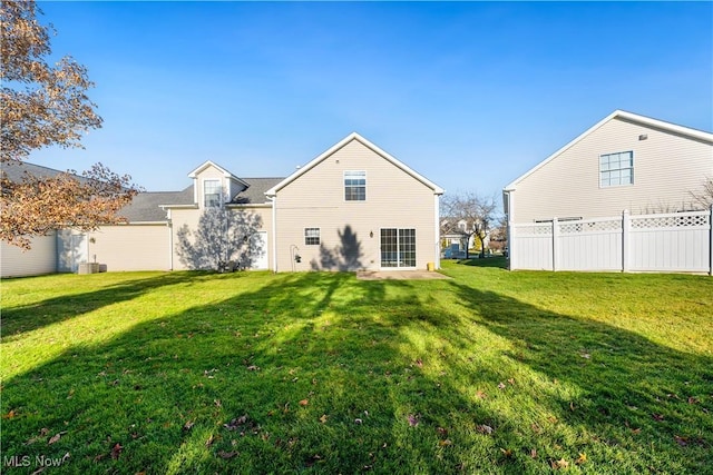 rear view of house featuring a lawn and central air condition unit