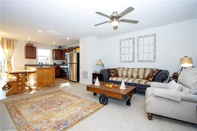 living room featuring ceiling fan and sink