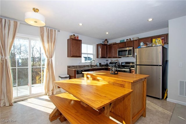 kitchen with a center island, stainless steel appliances, plenty of natural light, and sink