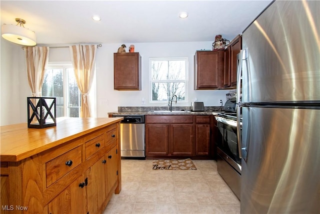 kitchen with sink, wooden counters, plenty of natural light, and appliances with stainless steel finishes