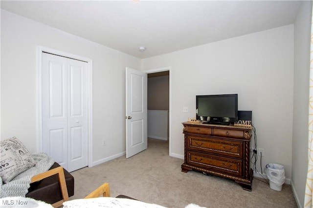 bedroom featuring light carpet and a closet