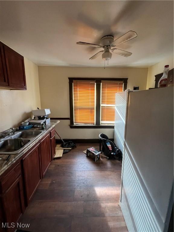 kitchen with white refrigerator, ceiling fan, dark wood-type flooring, and sink