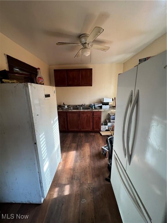 kitchen with dark hardwood / wood-style floors, white fridge, and ceiling fan