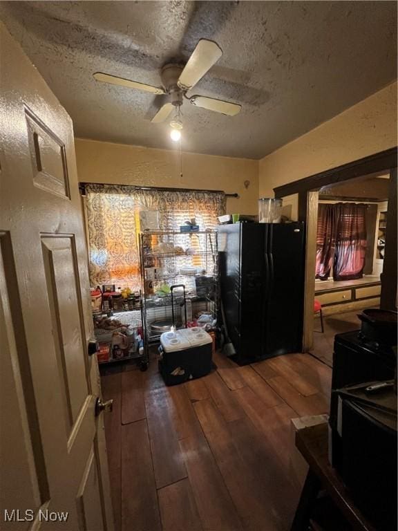 kitchen with black refrigerator, wood-type flooring, a textured ceiling, and ceiling fan