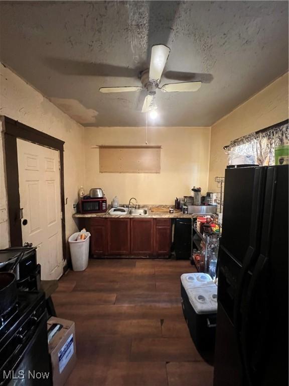 kitchen featuring ceiling fan, sink, dark wood-type flooring, a textured ceiling, and black fridge with ice dispenser