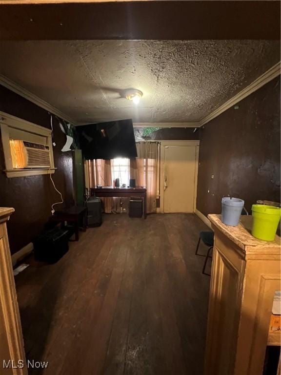 basement with a textured ceiling, dark wood-type flooring, and ornamental molding