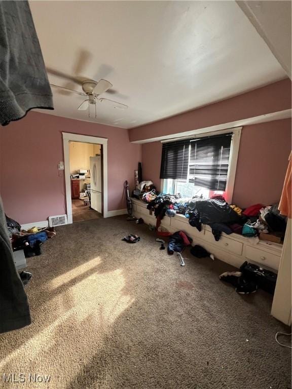 bedroom featuring dark colored carpet, stainless steel fridge, and ceiling fan