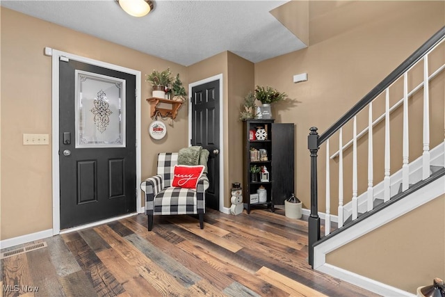 entryway with a textured ceiling and hardwood / wood-style flooring