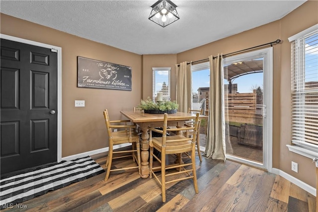 dining area featuring a textured ceiling and dark wood-type flooring