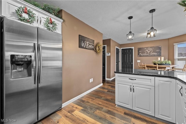 kitchen featuring a textured ceiling, dark hardwood / wood-style floors, white cabinetry, hanging light fixtures, and built in fridge