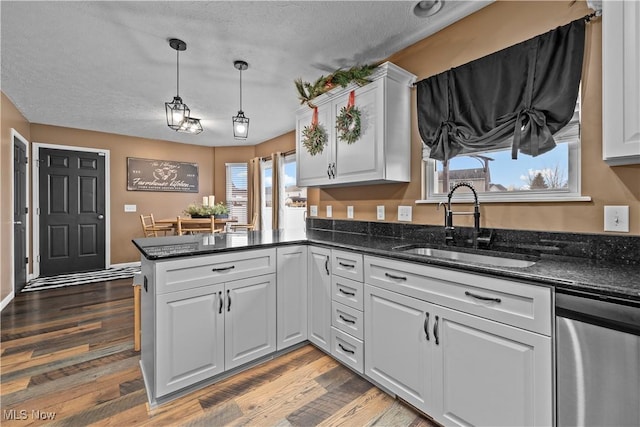 kitchen with kitchen peninsula, dark hardwood / wood-style flooring, white cabinets, and a textured ceiling