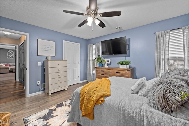 bedroom featuring ceiling fan, a textured ceiling, and hardwood / wood-style flooring