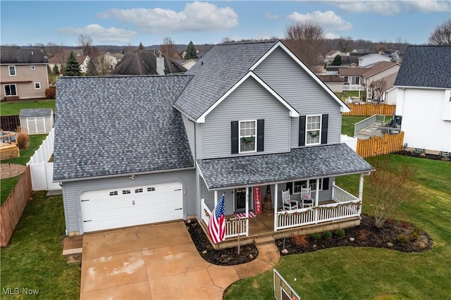 view of front of home with a garage, covered porch, and a front yard