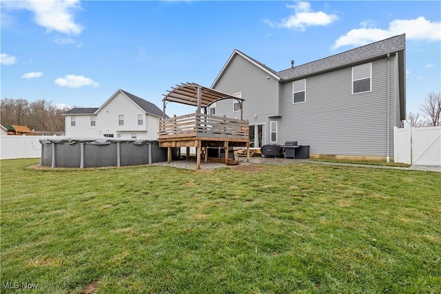 rear view of house featuring a swimming pool side deck and a yard