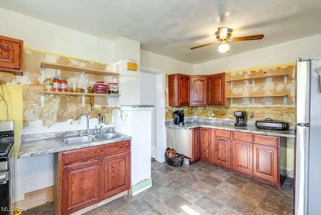 kitchen with backsplash, light stone counters, ceiling fan, sink, and stainless steel refrigerator