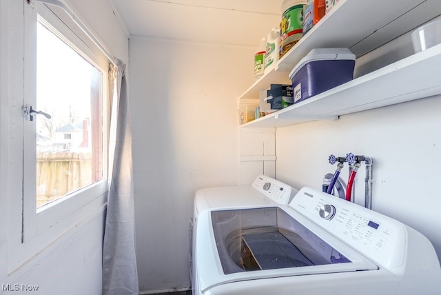 clothes washing area featuring separate washer and dryer and a wealth of natural light